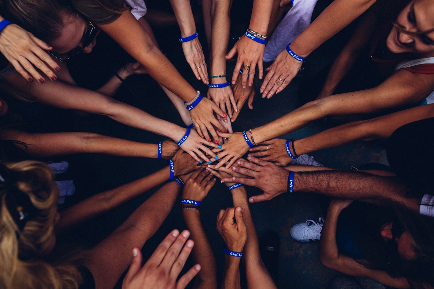 group of volunteers putting their hands in to the group