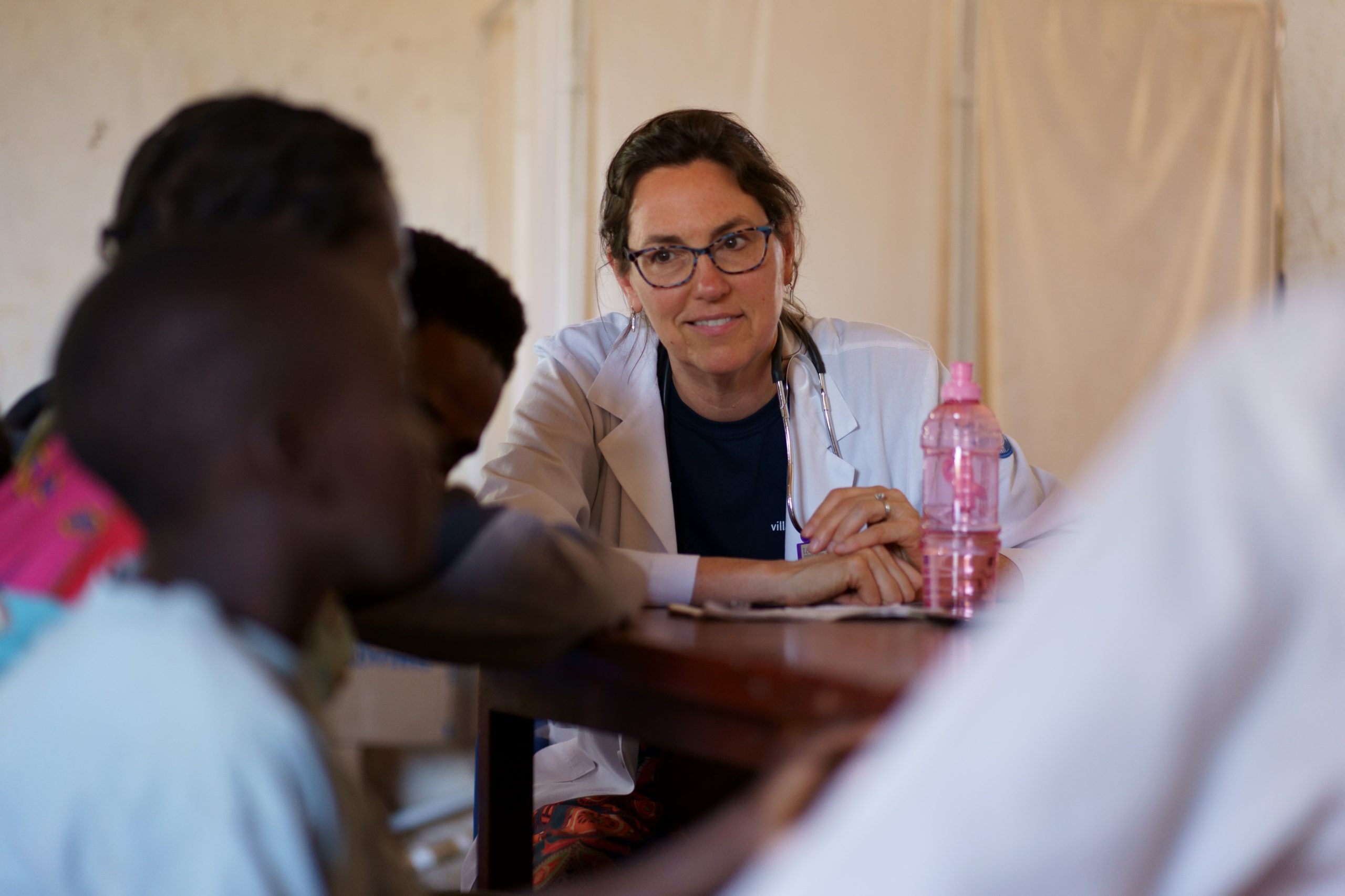 Dr. Edwards, Princeton internist, sitting with the children of Malawi