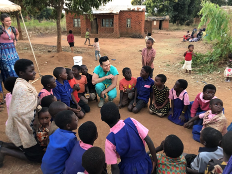 The people of Malawi sitting in a circle with Dr. Barbara R Edwards