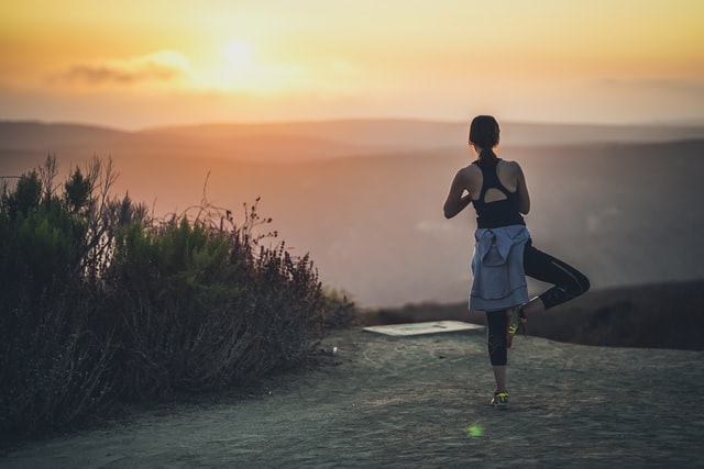 woman doing yoga during sunset