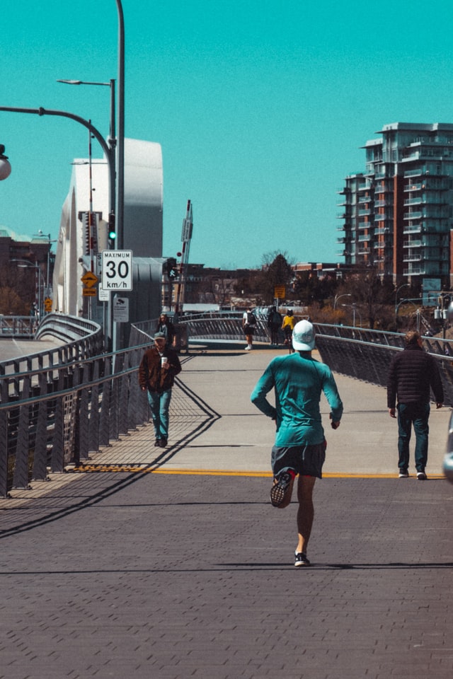 Man in blue jacket running in the daytime